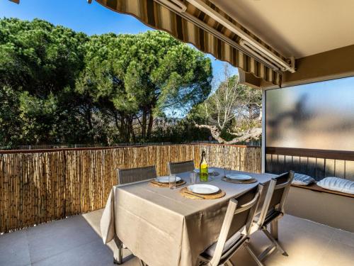 une salle à manger avec une table et des chaises sur un balcon dans l'établissement Apartment Parcs du Lavandou-9 by Interhome, au Lavandou