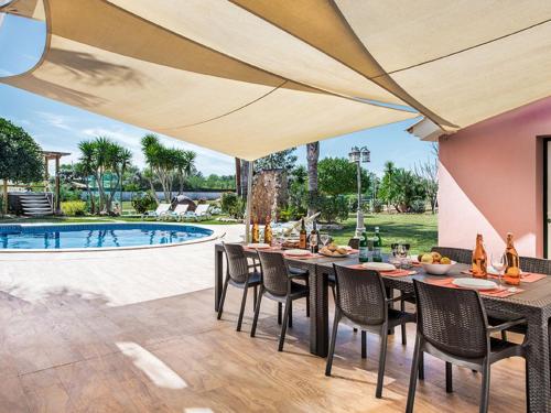 um pátio com uma mesa e cadeiras e uma piscina em Villa Quinta Valente by Interhome em Silves