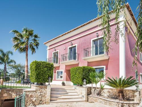 uma casa cor-de-rosa com uma palmeira em Villa Quinta Valente by Interhome em Silves