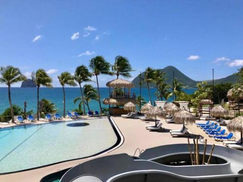 勒迪亚芒Ma place au Soleil, l'Escapade romantique的一个带游泳池和椅子的度假胜地和大海