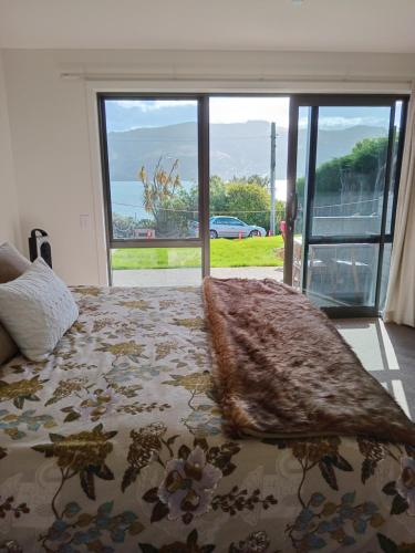 a bedroom with a bed with a large window at The Views in Dunedin