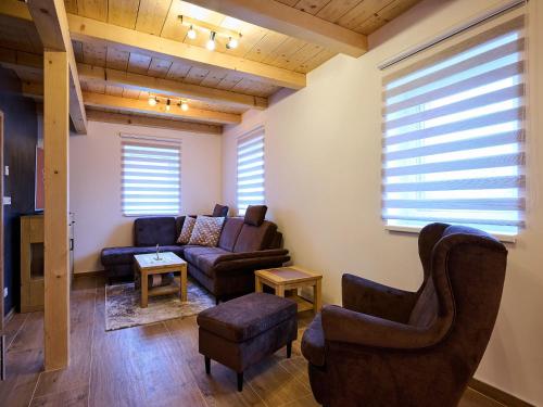 a living room with a couch and a chair at Chalet Pod lesem by Interhome in Smržovka