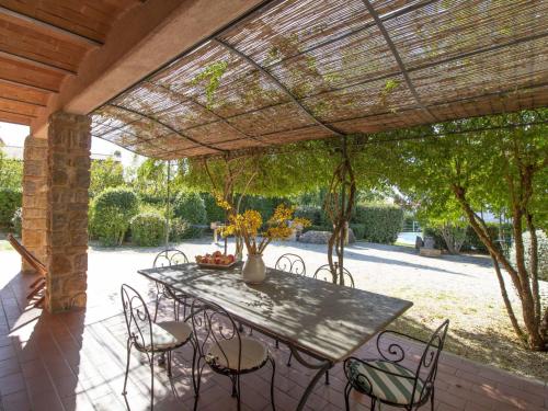 a patio with a table and chairs under a pergola at Villa La Gattaiola by Interhome in Montemerano