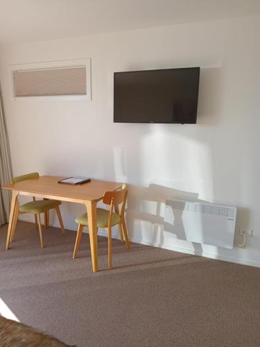 a room with a table and a tv on a wall at The Views in Dunedin