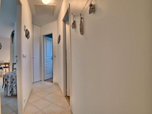 a hallway with a white wall and a table at Holiday Home La Parie 1 by Interhome in Dolus d'Oléron