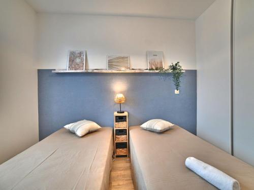 a bedroom with two beds and a blue wall at Holiday Home La Parie 1 by Interhome in Dolus d'Oléron