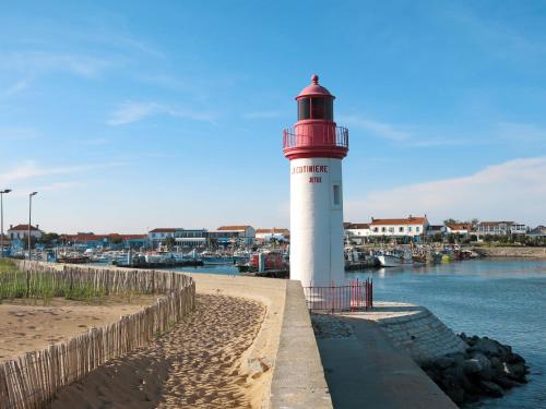 a red and white lighthouse sitting next to the water at Holiday Home La Parie 1 by Interhome in Dolus d'Oléron