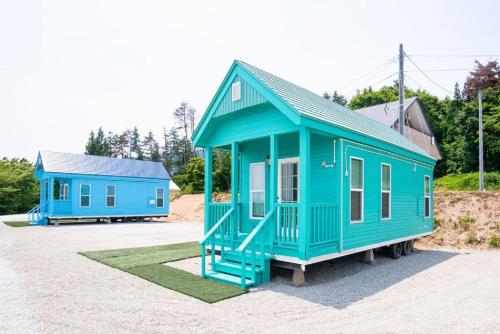 two blue tiny houses sitting in a parking lot at Nagai Peony Forest Campsite - Vacation STAY 27777v in Yamagiwa
