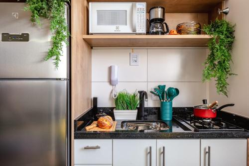 y cocina con fogones y nevera. en Allianz Parque - Apartamento com Vista Incrível e Academia, en São Paulo