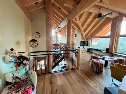 a living room with wooden ceilings and a staircase at Chalet Schwarzwaldchalet de luxe mit Sauna by Interhome in Heitersheim
