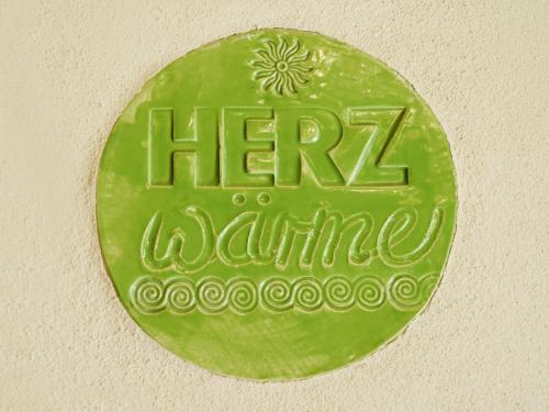 a green sign on a wall with the words hermite at Chalet Schwarzwaldchalet de luxe mit Sauna by Interhome in Heitersheim