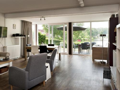 a living room with chairs and a dining room at Holiday Home Vrieschehuis Comfort Royaal by Interhome in Vlagtwedde