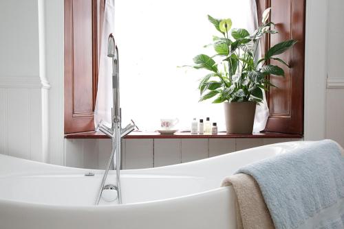 a bathroom with a bath tub with a faucet at Kittiwake House- charming coastal home in Saint Monance