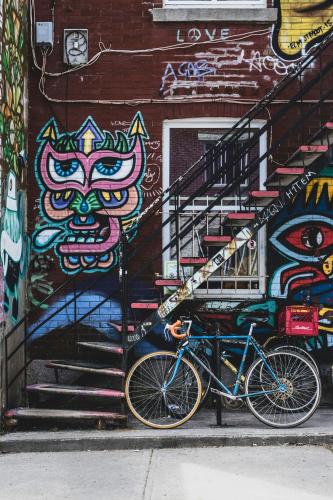 a bike parked in front of a building with graffiti at Clouds Lofts - Quartier Latin in Montréal