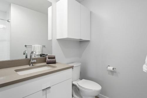 a white bathroom with a toilet and a sink at Perfect Peak, Unit 2B in Fraser