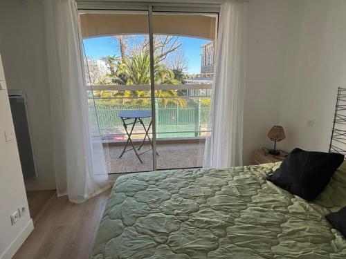 une chambre avec un lit et une grande fenêtre dans l'établissement T2 Arcachon vacances et plages a 300 mètres, à Arcachon