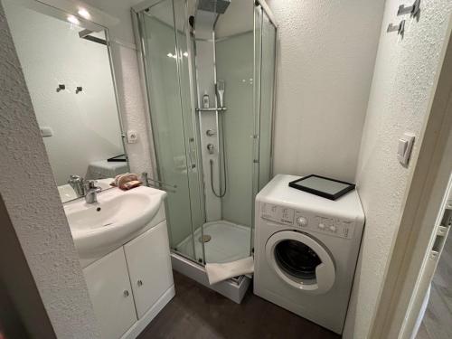 une salle de bain avec une machine à laver et un lavabo dans l'établissement T2 Arcachon vacances et plages a 300 mètres, à Arcachon