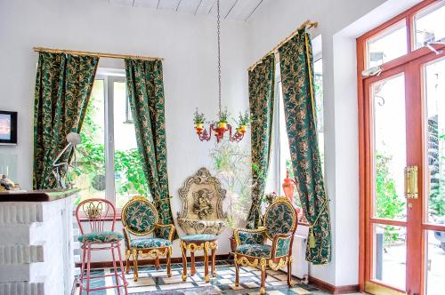 a dining room with chairs and windows at Guest House De Rishelye in Odesa