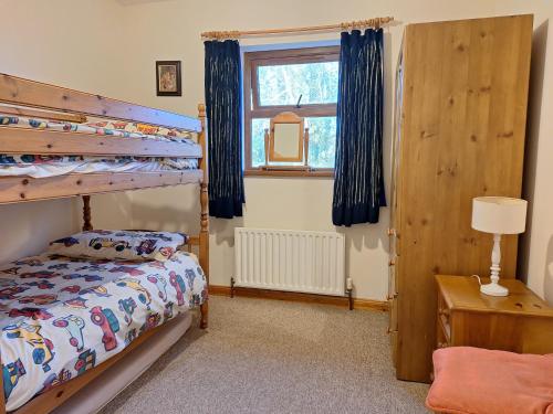 a bedroom with a bunk bed and a window at Beautiful Lakeside Holiday Home (6 Portinode Cottages) in Enniskillen