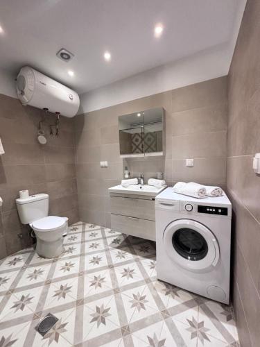 W łazience znajduje się pralka i umywalka. w obiekcie The Port House Sea Breeze w mieście Agios Georgios