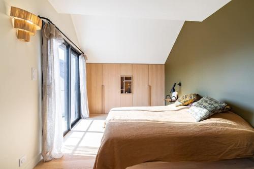 une chambre avec un grand lit et une grande fenêtre dans l'établissement Coup de cœur, bord de mer - jusqu'à 12 voyageurs !, à Sarzeau