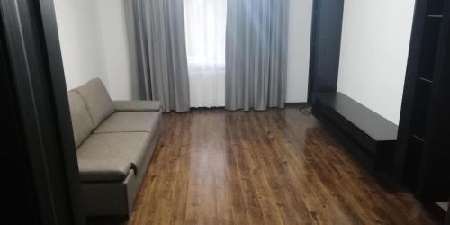 sala de estar con sofá y suelo de madera en Apartament 2 camere Ultracentral, en Tîrnăveni