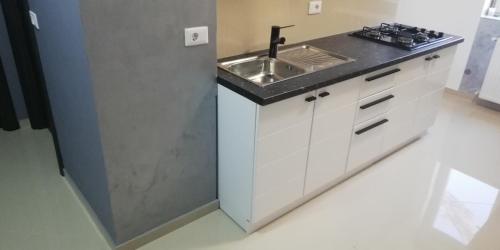 uma pequena cozinha com um lavatório e um fogão em Apartament 2 camere Ultracentral em Tîrnăveni