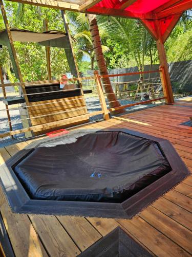 a black mat on a wooden deck with a tent at Bungalow Ti Koko in Le Gosier
