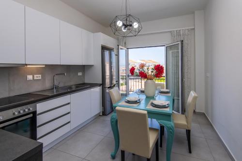 uma cozinha com uma mesa e cadeiras azuis e uma janela em Karlovasi Comfy Retreat em Ríva