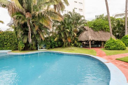 a large blue swimming pool in a resort with palm trees at Playa / ubicación / tranquilidad in Bucerías