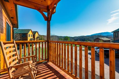 a wooden porch with a rocking chair on a deck at Full Equipped Cabin with a Pool and Game Room Smokies Views in Gatlinburg