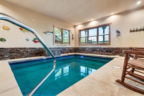 a swimming pool in a house with a bench at Full Equipped Cabin with a Pool and Game Room Smokies Views in Gatlinburg