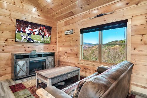 a living room with a couch and a fireplace and a tv at Full Equipped Cabin with a Pool and Game Room Smokies Views in Gatlinburg