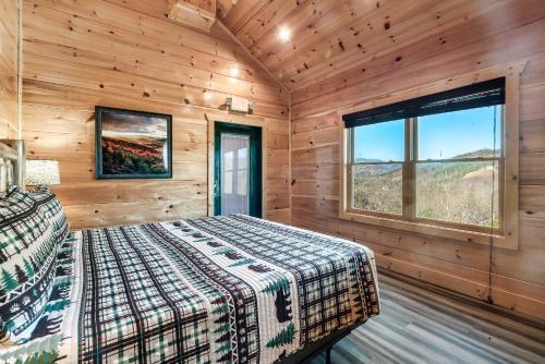 a bedroom with a bed and a window in a cabin at Full Equipped Cabin with a Pool and Game Room Smokies Views in Gatlinburg