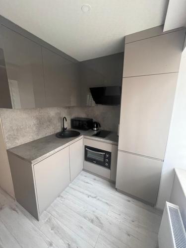 a small kitchen with a sink and a stove at ZE Apartments in Rēzekne
