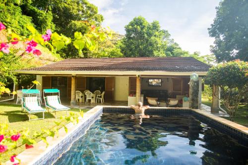 a swimming pool in front of a house at Coté Sud - Unique Villa & Bungalows Intendance Road in Takamaka