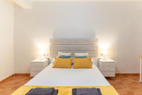 1 dormitorio con 1 cama blanca grande y 2 mesitas de noche en Trendy Homes Catedral, en Almería