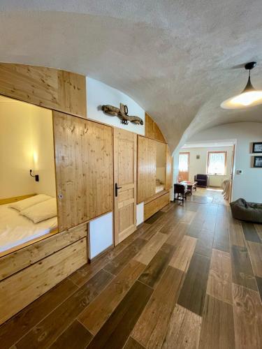 a large room with a bed and wooden cabinets at La MaiZon du Bois in Champagny-en-Vanoise