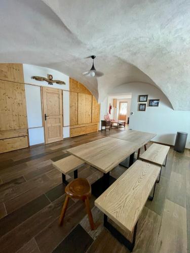 a large room with wooden tables and a ceiling at La MaiZon du Bois in Champagny-en-Vanoise