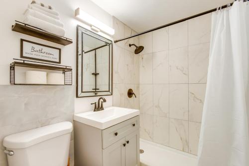 een witte badkamer met een wastafel en een douche bij Sheridan Vacation Rental Home with Patio and Gas Grill in Sheridan