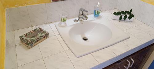 un lavabo blanco en un baño de azulejos blancos en Casa Giò en Las Terrenas