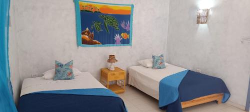 una camera con due letti e un dipinto sul muro di Casa Giò a Las Terrenas