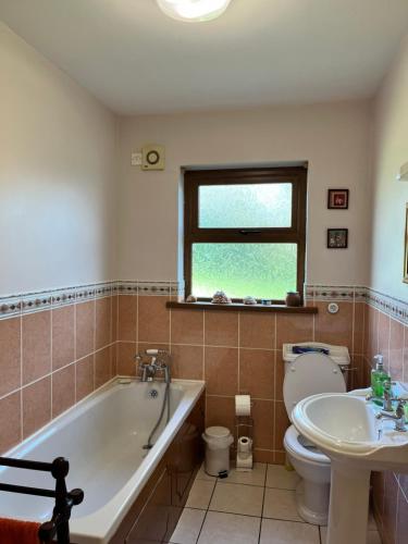 uma casa de banho com uma banheira, um WC e um lavatório. em Beautiful Lakeside Holiday Home (6 Portinode Cottages) em Enniskillen