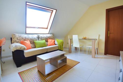 uma sala de estar com um sofá e uma mesa em Apartamento con terraza frente al mar en O Grove em O Grove