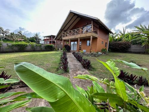 a house with a porch and a yard with plants at Cabañas Anavai Rapa Nui in Hanga Roa