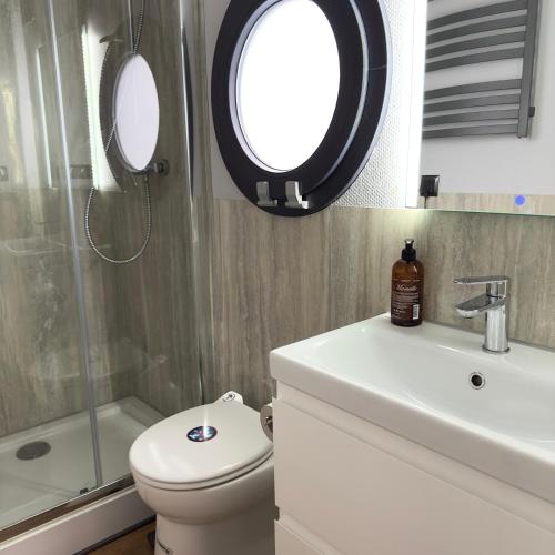 a bathroom with a toilet and a sink and a mirror at La Mare Resort in Gothenburg