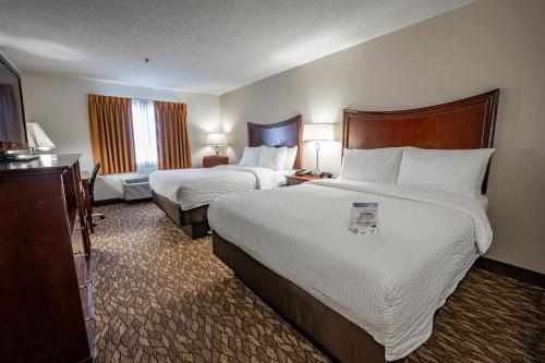 a hotel room with two beds and a television at Christopher Inn and Suites in Chillicothe