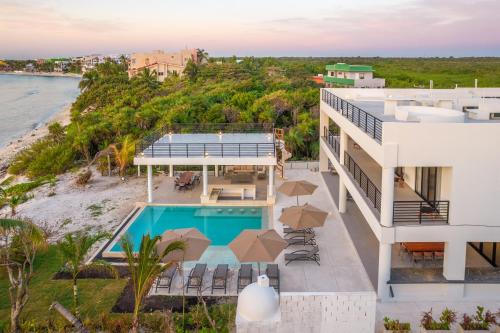 an aerial view of a house with a swimming pool and the ocean at CASA MILAH TULUM 8BDR BEACH FRONT PRIVATE-CHEF VILLA WEDDINGS-RETREATS-FAMILY GATHERINGS in Akumal