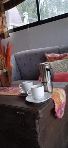 two cups and saucers sitting on a wooden table at Mirar&Soñar in Chantada