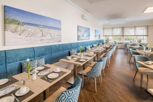 a dining room with wooden tables and chairs at Hotel Bellevue in Timmendorfer Strand